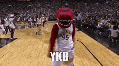 a mascot on a basketball court with ykb written on the floor