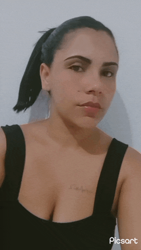 a woman wearing a black tank top has a tattoo on her chest that says i love you