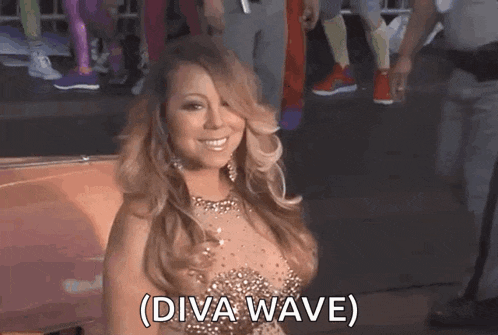 mariah carey is wearing a very revealing dress and smiling .