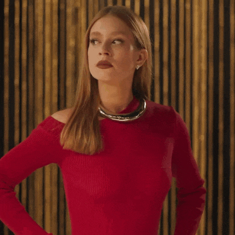 a woman wearing a red sweater and a gold necklace