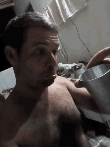 a man without a shirt is holding an aluminum pot
