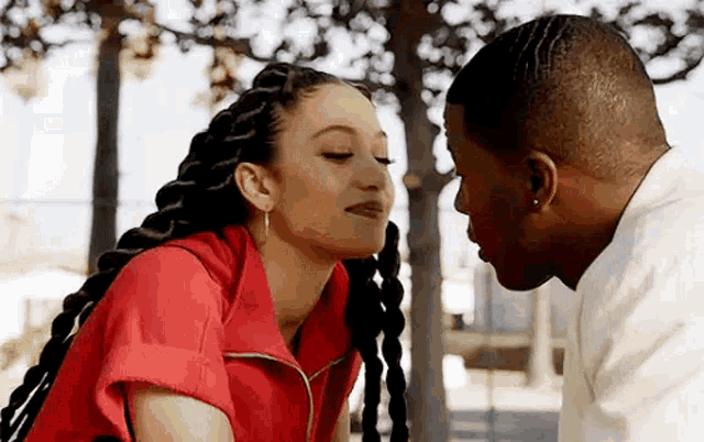 a man and a woman are kissing each other on the forehead .