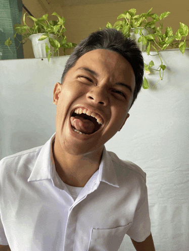 a man in a white shirt is making a funny face