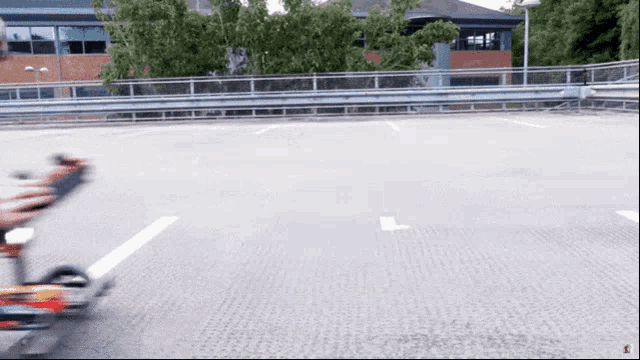 a person is riding a scooter in a parking lot with a building in the background
