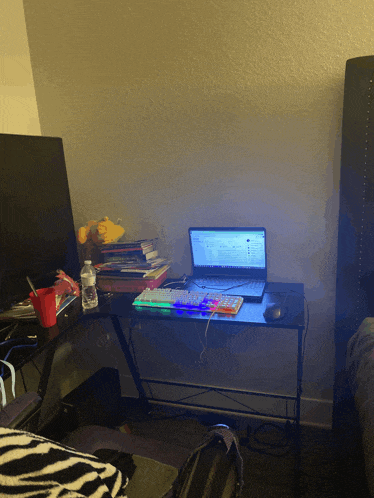 a laptop sits on a desk with a keyboard and mouse
