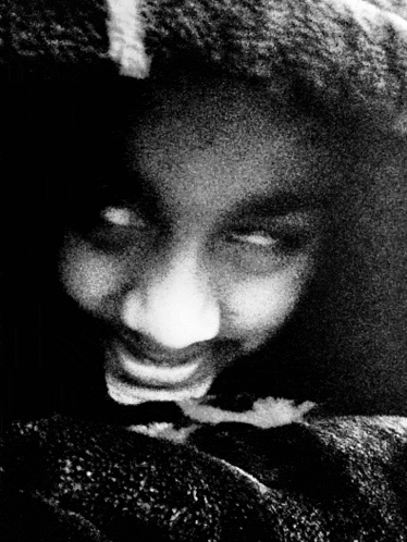 a black and white photo of a person 's face with a blurred background