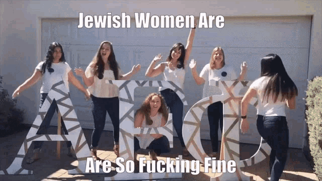 a group of women standing in front of large letters that say abc