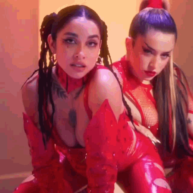 two women are posing for a picture together in red outfits .