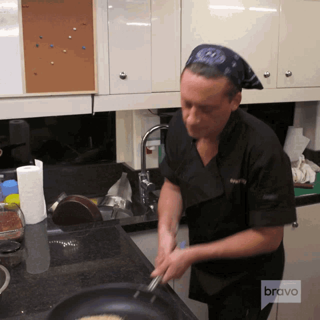 a man cooking in a kitchen with bravo on the bottom