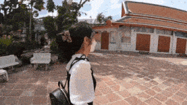 a woman wearing a mask is walking in front of a building