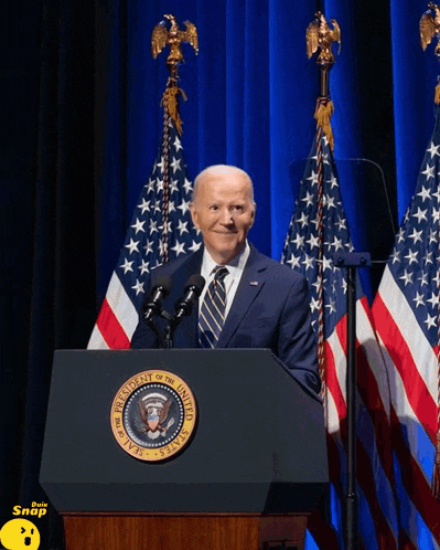a man stands behind a podium that says president of the united states