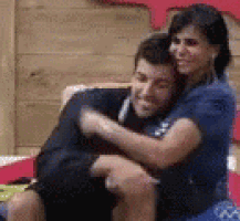 a man and a woman are hugging each other on a bed .