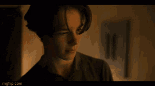 a close up of a young man 's face in a dark room