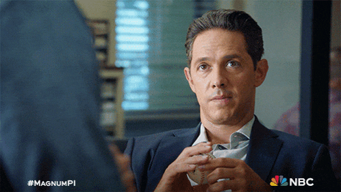 a man in a suit is talking to another man with the nbc logo behind him