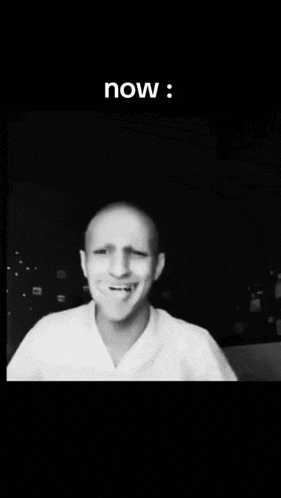 a black and white photo of a bald man with his hands on his head