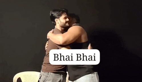 two men are hugging each other in front of a black background with the words bhai bhai written on it .