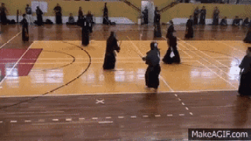 a group of people are practicing martial arts on a court