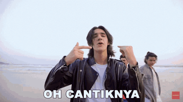a man in a leather jacket is pointing his finger at his face and the words oh cantiknya are below him