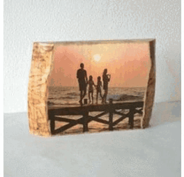 a picture of a family standing on a dock at the beach .