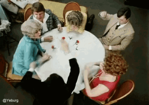 a group of people are sitting around a table with roses on it and a caption that says yeburg