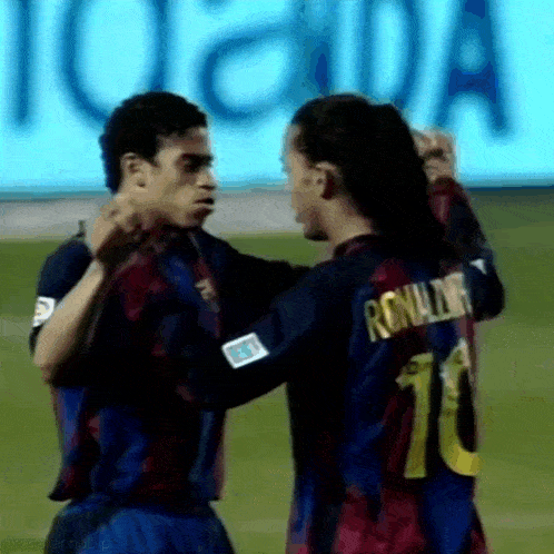 two soccer players are hugging each other on a field .