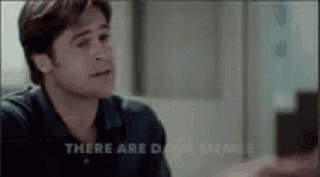 a man in a blue shirt is sitting in a room with the words `` there are dawn memes '' written on the screen .