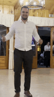 a man in a white shirt and black pants is dancing on a dance floor .