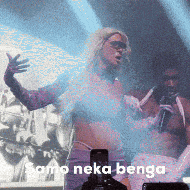 a woman singing into a microphone with the words samo neka benga in the background