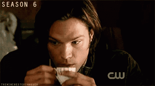 a man is blowing his nose with a napkin and the season 6 logo is visible behind him