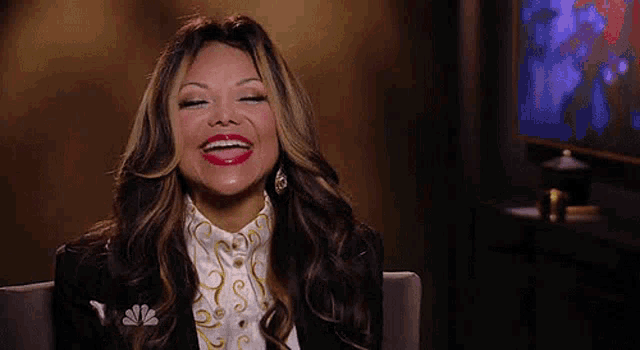 a woman is sitting in a chair with her eyes closed and smiling .