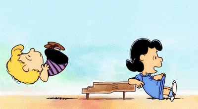 a cartoon of charlie brown and lucy brown laying on a beach