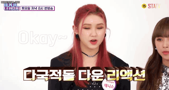 a girl with red hair says okay while another girl looks on