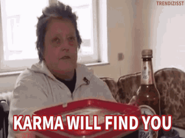 a woman is sitting at a table with a tray and a bottle of beer and the words karma will find you above her