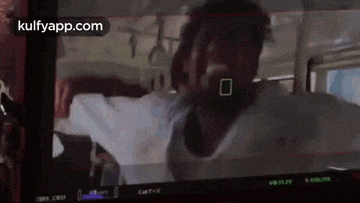 a man in a white shirt is standing in front of a camera on a screen .