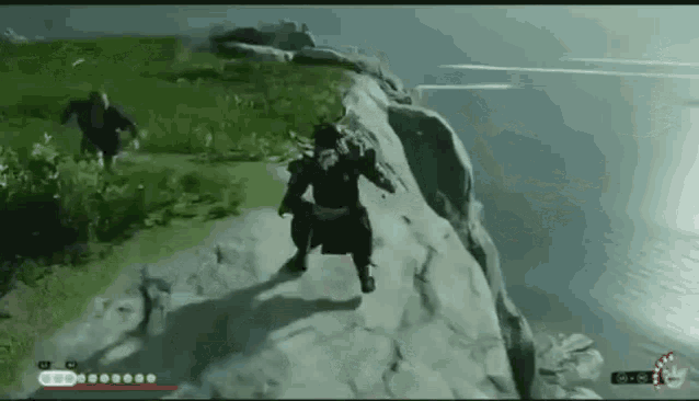 a man is standing on top of a cliff next to a body of water in a video game .