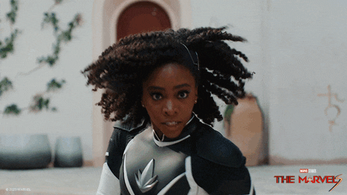a woman in a superhero costume with the marvel logo on the bottom right