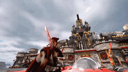 a man in a red cape is holding a sword in front of a large castle