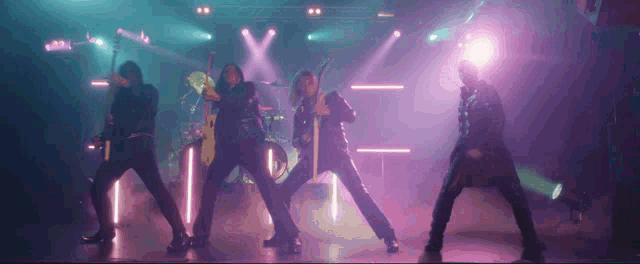 a group of people dancing on a stage with purple lights behind them
