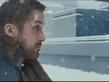 a man with a beard is standing in the snow .