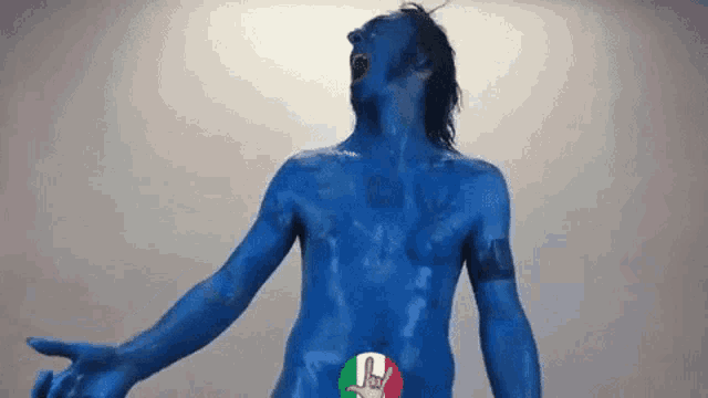 a naked man with blue paint on his body has a i love you sign on his chest