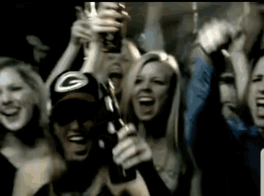 a man wearing a green bay packers hat is holding a beer