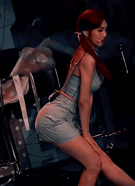 a woman in a blue top and skirt is standing on a stage