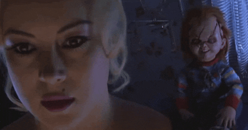 a woman is looking at a chucky doll in a movie scene