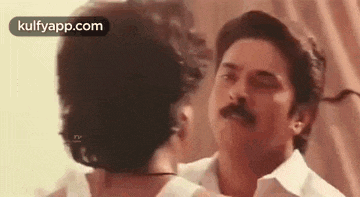 a man and a woman are standing next to each other and kissing .
