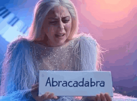 a woman in a white dress is holding a sign that says abracadabra .