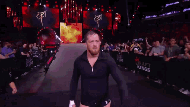 a man in a black shirt stands in a ring with the word king on it