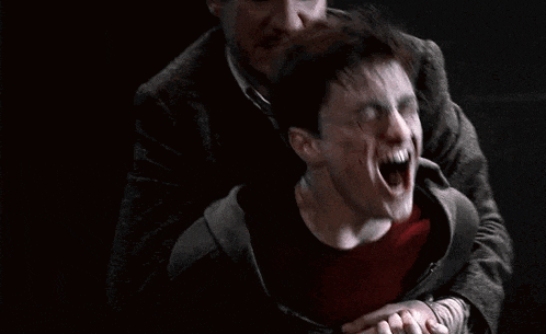 harry potter is screaming in pain while being held by a man .
