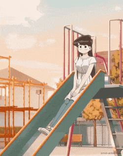 a girl is sitting on a slide in a park