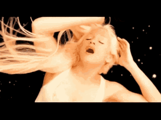 a woman with blonde hair is making a funny face with her mouth open