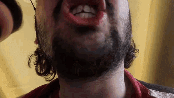 a man with a beard has his mouth open and his teeth showing